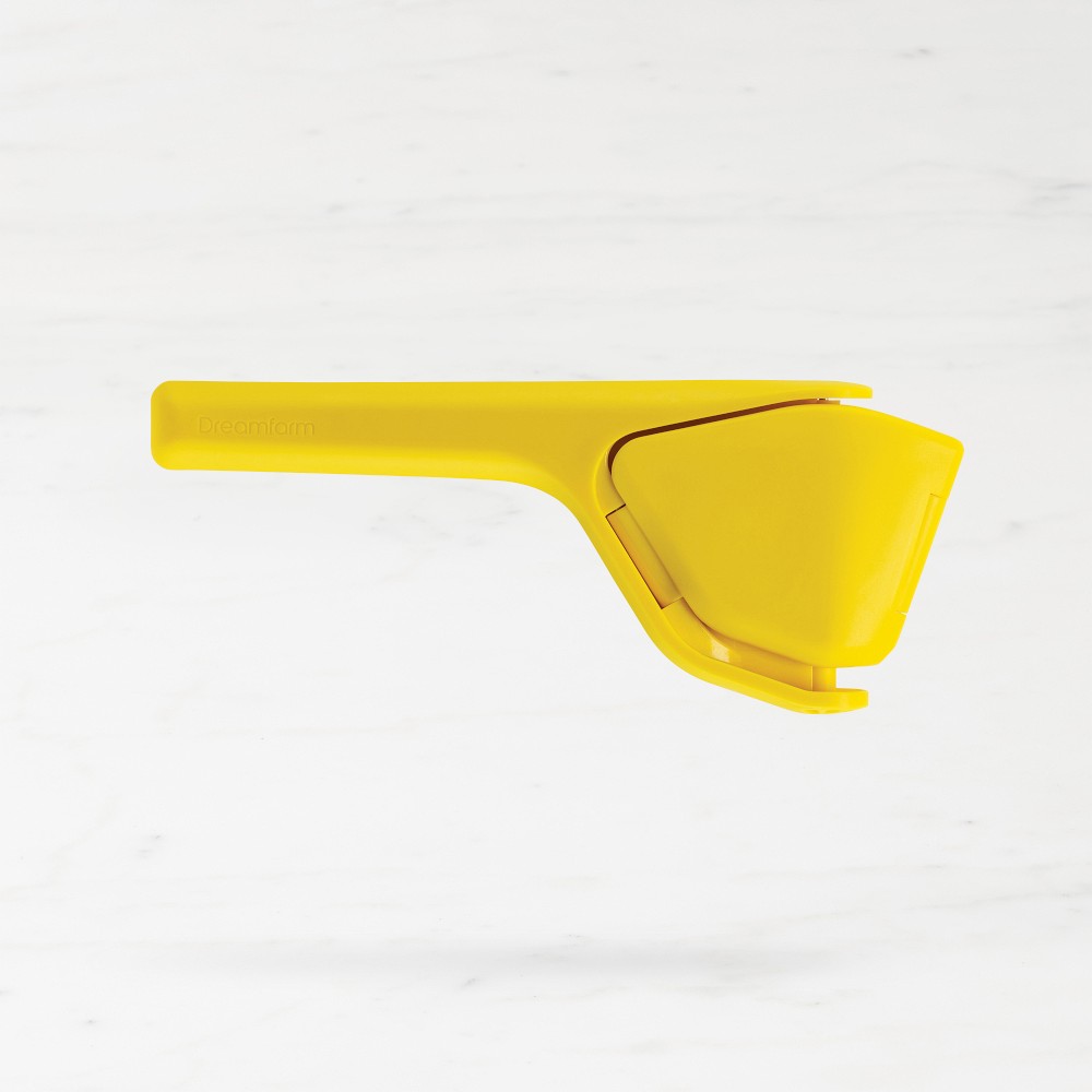 Dreamfarm Fluicer hand-press citrus juicer in lime green, shown folded flat