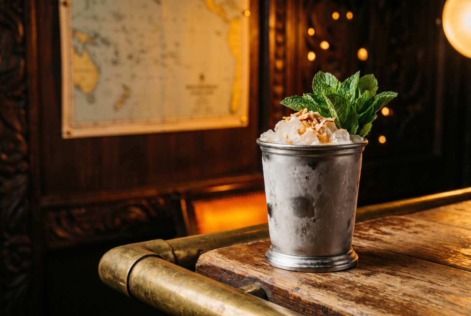 Coconut Mint Julep in a frosted pewter cup heaped with crushed ice, a dark rum float and a fresh mint bouquet, in the dim Forbidden Altar bar